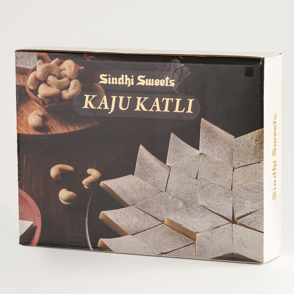 Box of Sindhi Sweets Kaju Katli with cashews on a white background