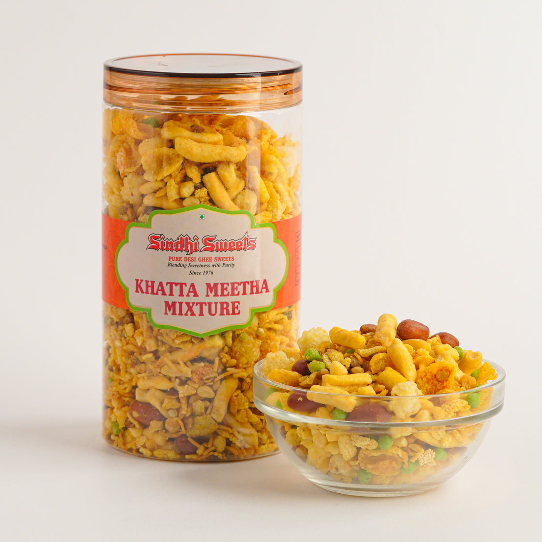 Jar and bowl of Sindh sweets Khatta Meetha Mixture on a white background
