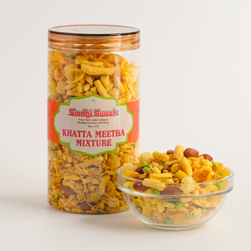 Jar and bowl of Sindh sweets Khatta Meetha Mixture on a white background