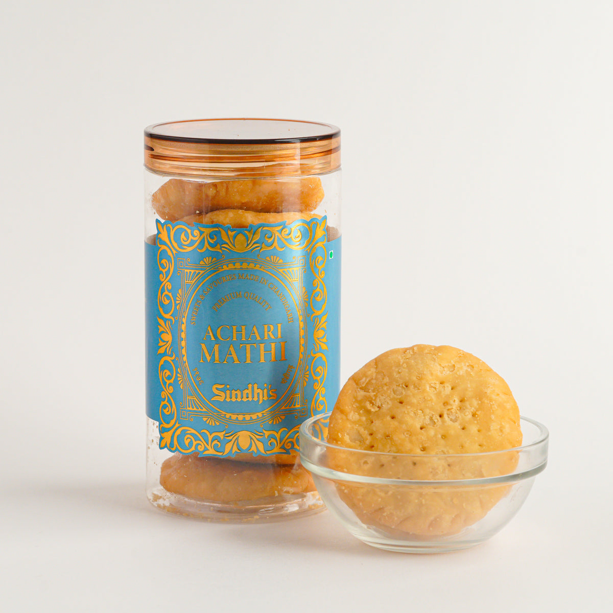 Jar of 'Achari Math' cookies with a blue label on a white background