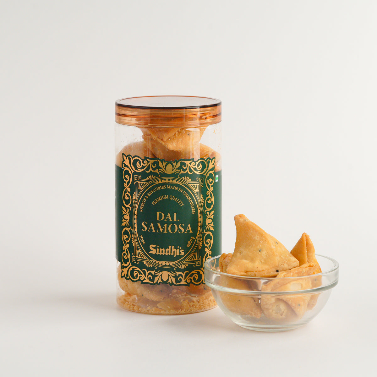 Jar of Dai Samosa Sindhi with a small bowl of samosas on a white background