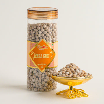 Jar of Sindhi's Jeera Goli with a decorative lid on a light background