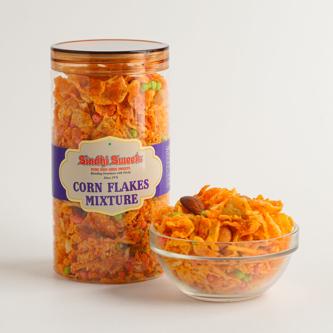 Jar and bowl of corn flakes mixture with Siddhi Sweets label on a white background