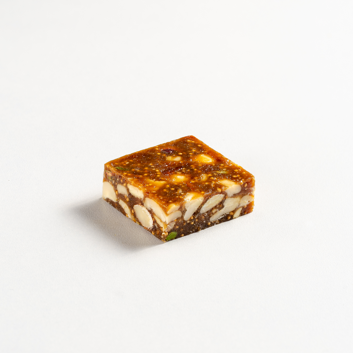 Square piece of nougat with nuts on a white background