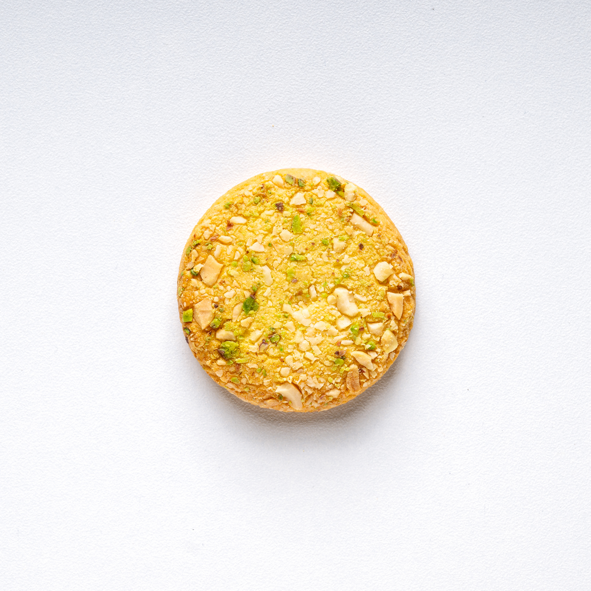 Round yellow cookie with nuts on a white background