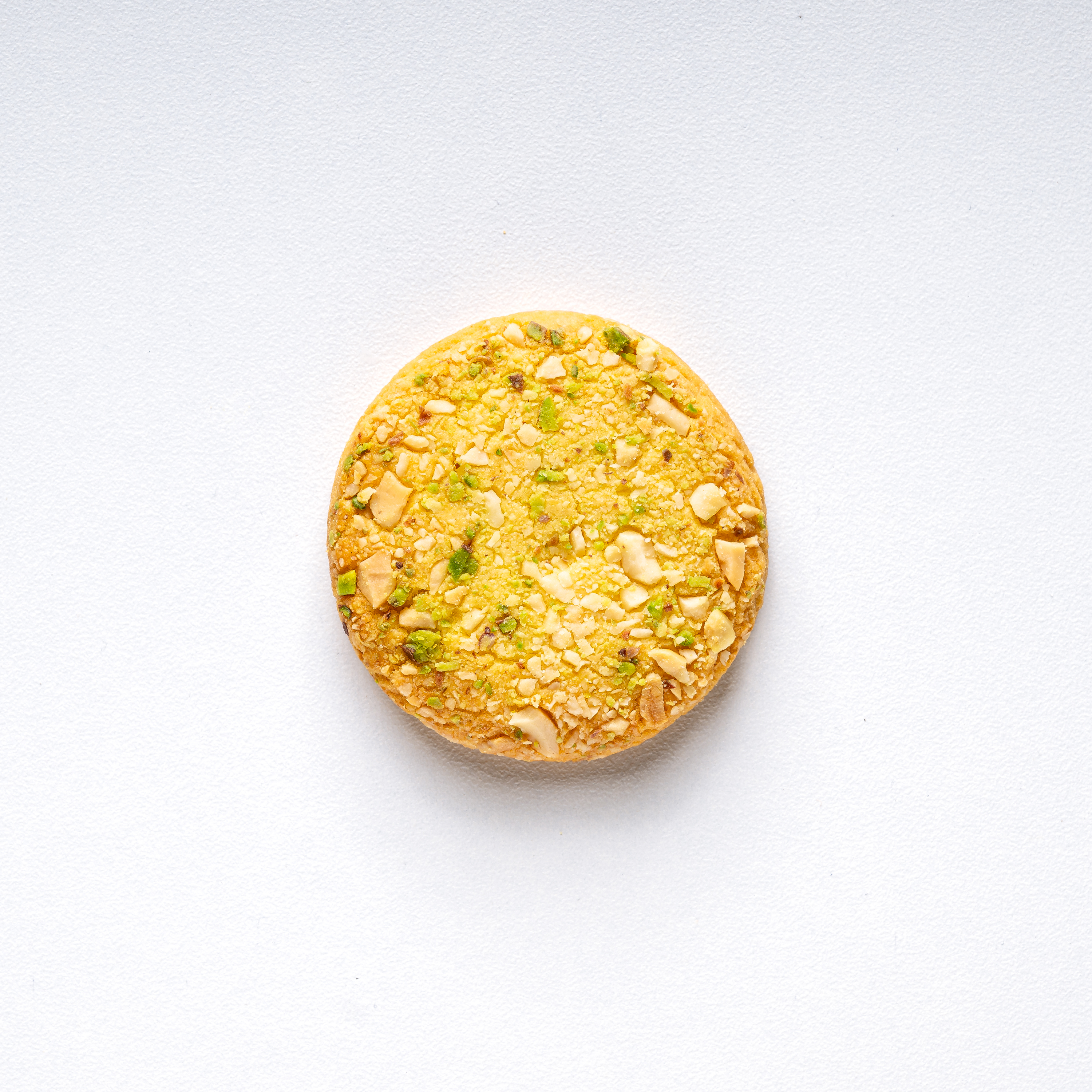 Round yellow cookie with nuts on a white background