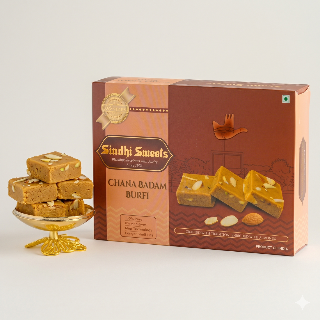 Sindhi Sweets Chana Badam Burfi packaging with a gold bowl of burfi on a white background