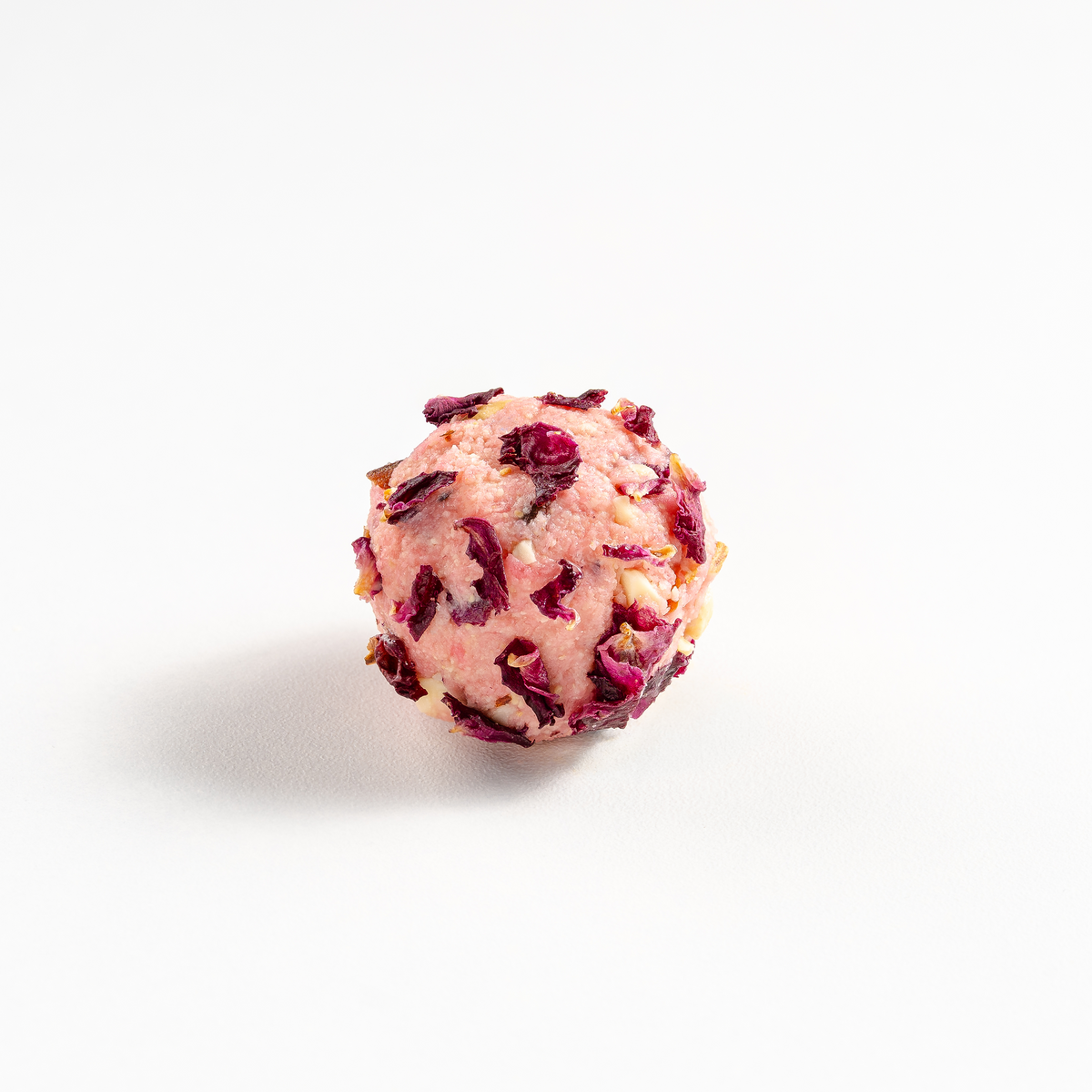 Pink truffle with red bits on a white background
