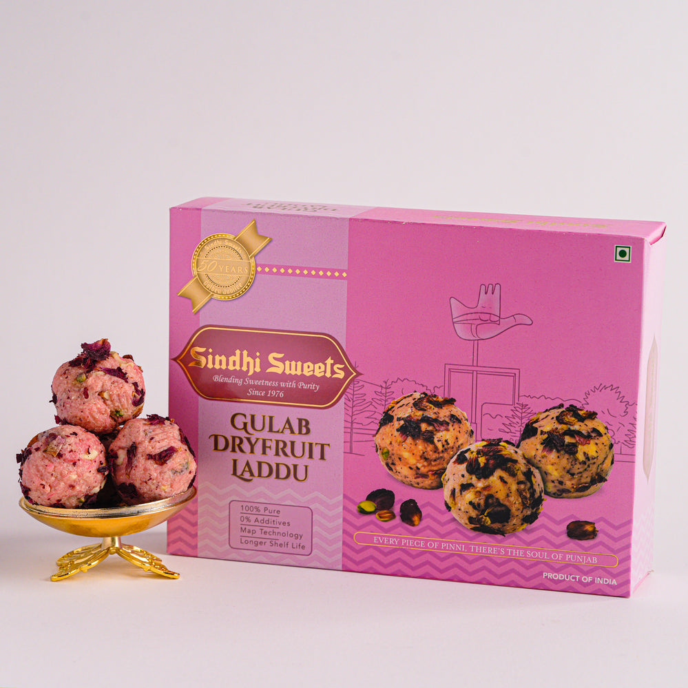 Pink box of Sindhi Sweets Gulab Dryfruit Laddu with laddu on a white background