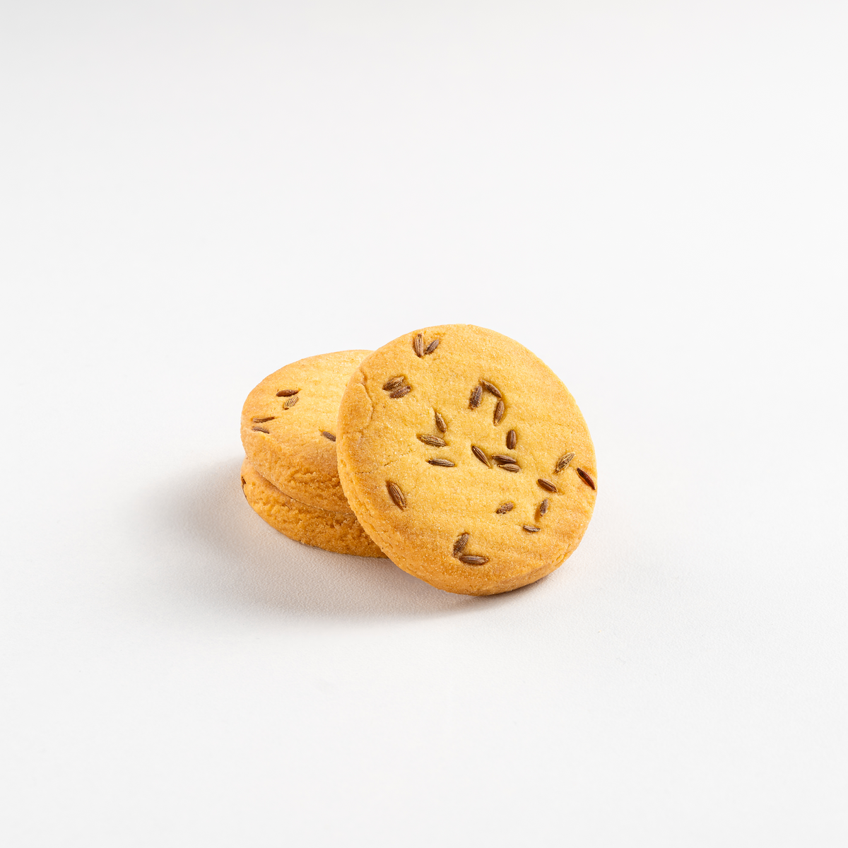 Two round cookies with seeds on a white background
