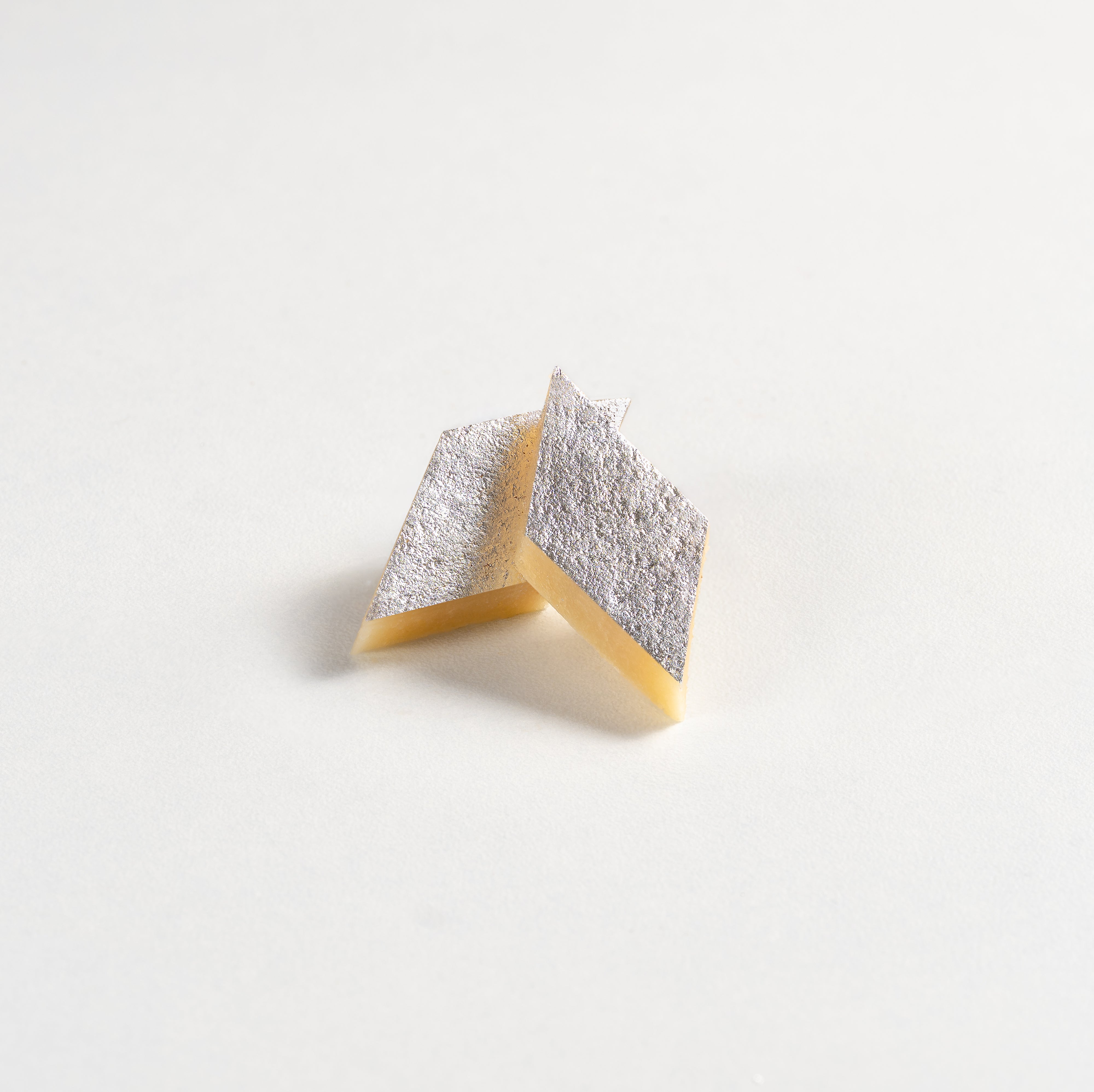 Two diamond-shaped sponges with one yellow and one multicolored on a light gray background
