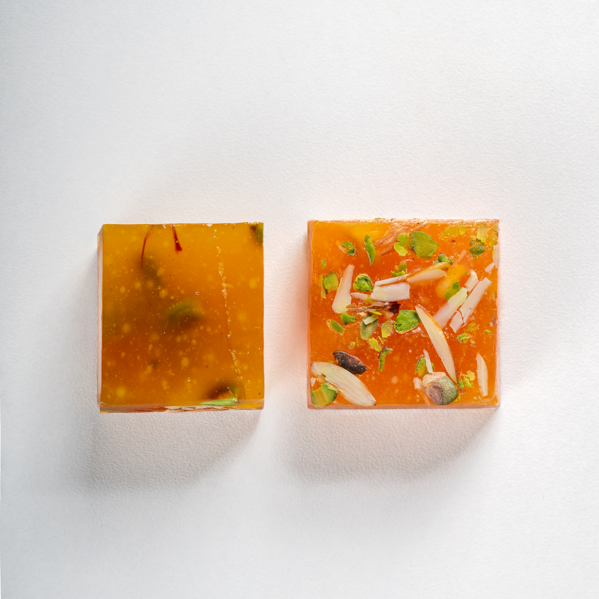 Two square soap bars with decorative elements on a white background
