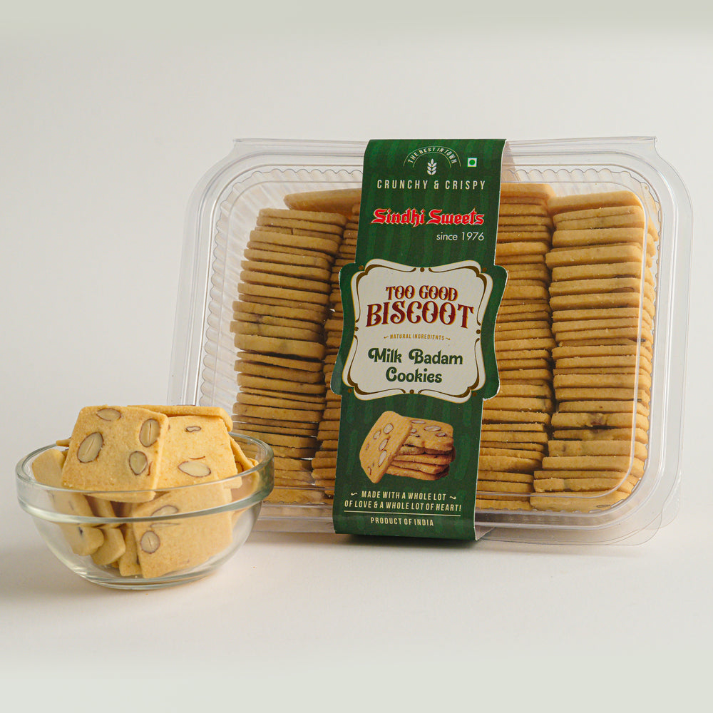 Packaged milk badam cookies with a bowl of cookies on a white background