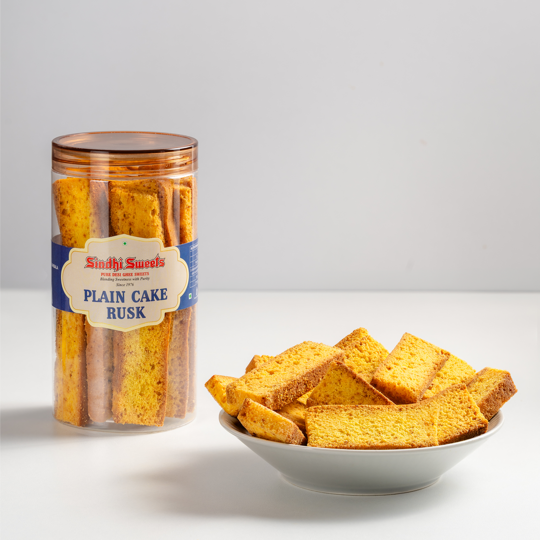Jar of plain cake rusk and a bowl of rusk on a light gray background